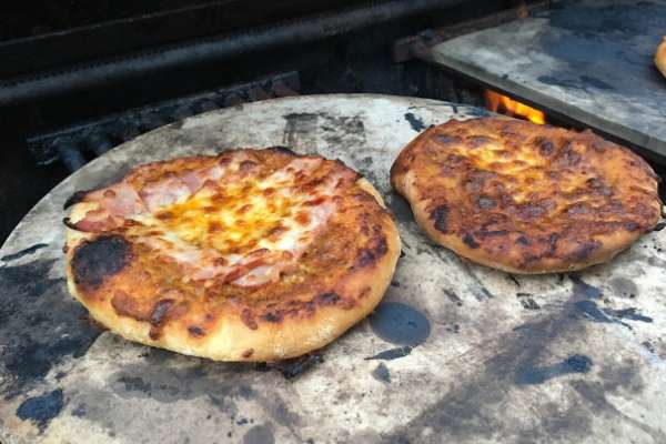 Pizza outdoors on a pizza stone