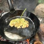 Elderflowers fried on a campfire pan