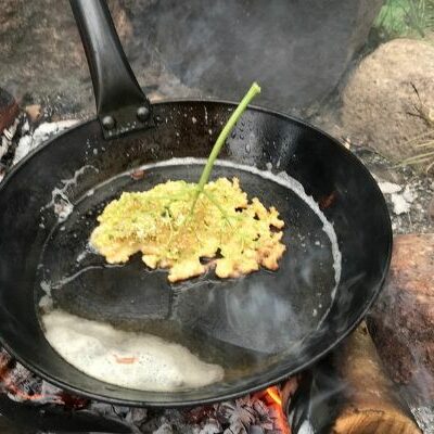Elderflowers fried on a campfire pan
